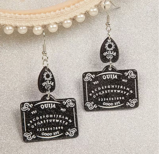 Black glitter Ouija board dangle earrings with white spirit board lettering, decorative planchette accents and silver-tone hooks