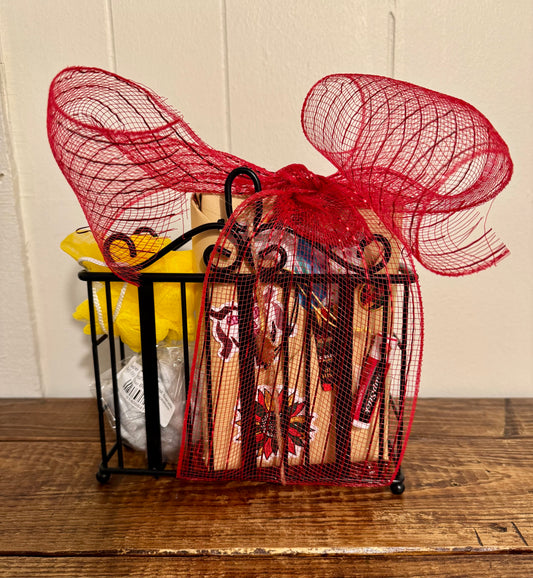 Decorative gift basket with red mesh cover on a wooden surface