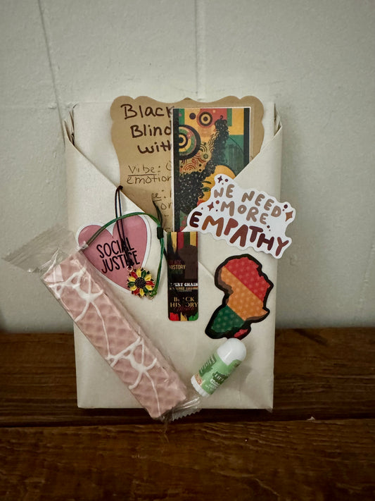 Collection of social justice-themed items including a bookmark, stickers, and a pen on a white surface.
