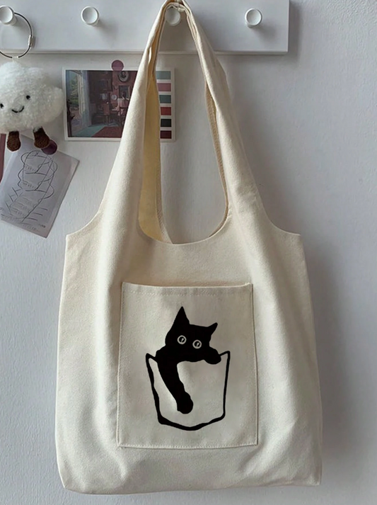 Beige tote bag with a black cat illustration on a white wall.