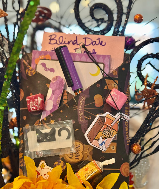 Product packaging with various items and a pen, set against a Halloween-themed background.