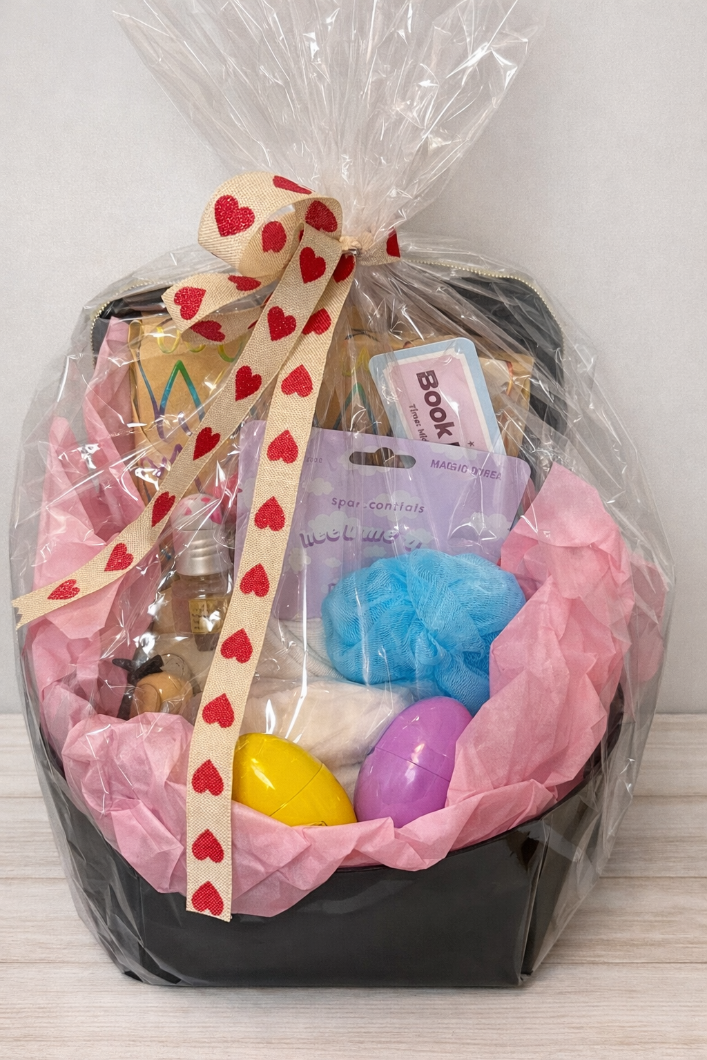 Blind Date with a Book gift basket wrapped in cellophane featuring a hidden historical mystery novel with LGBTQ themes and self-care treats.