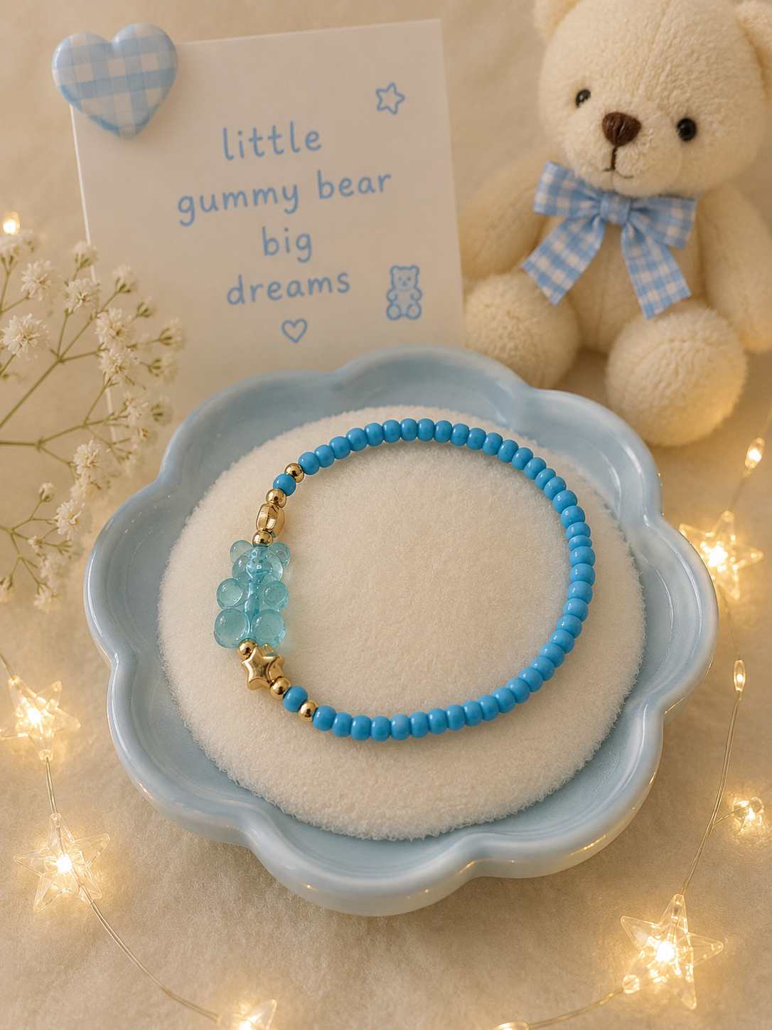 Blue stretch bead bracelet with transparent gummy bear charm and gold accents in pastel blue display