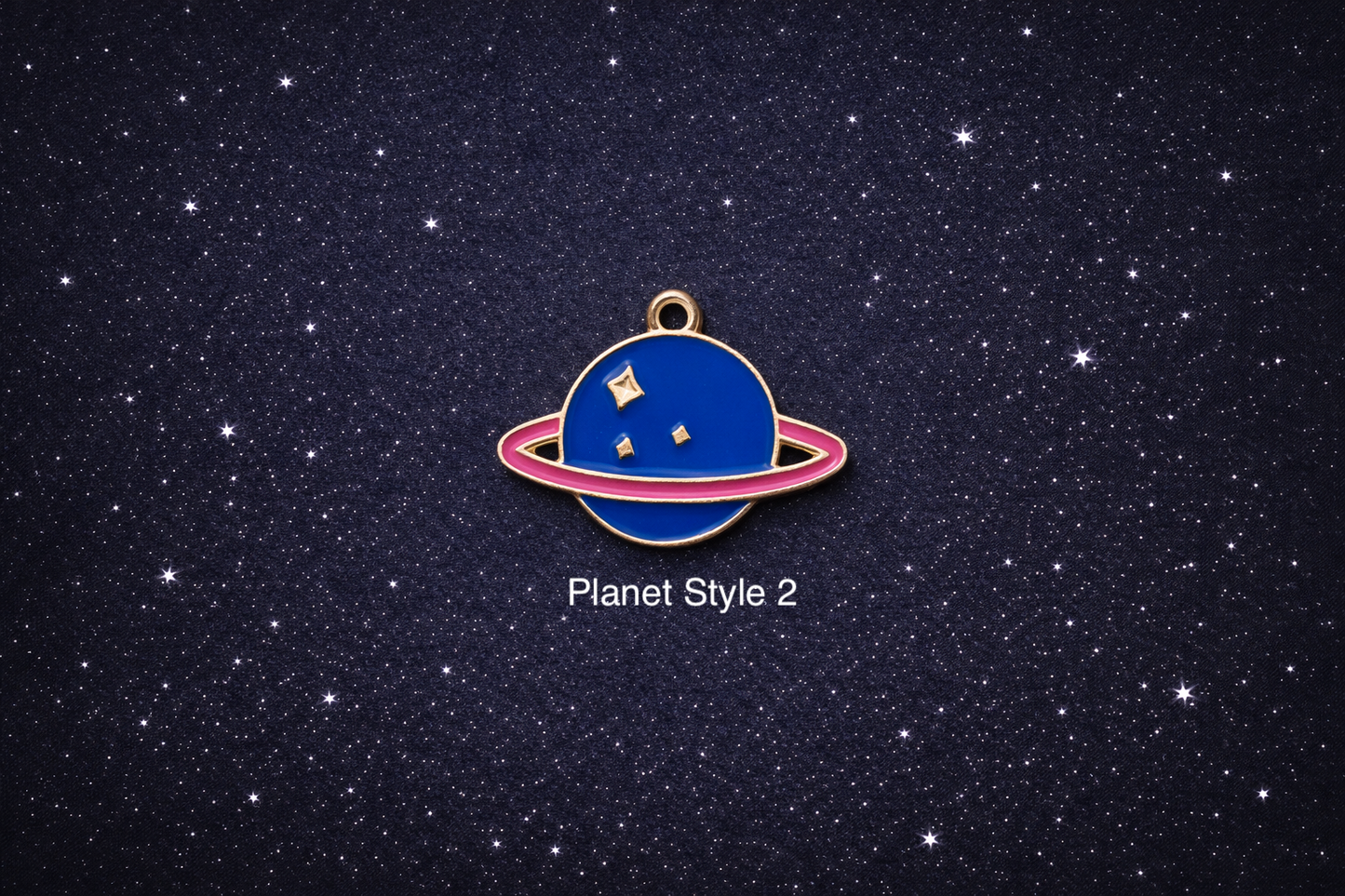 Blue planet enamel charm with a pink ring and small gold star details, shown on a dark starry background and sold individually.