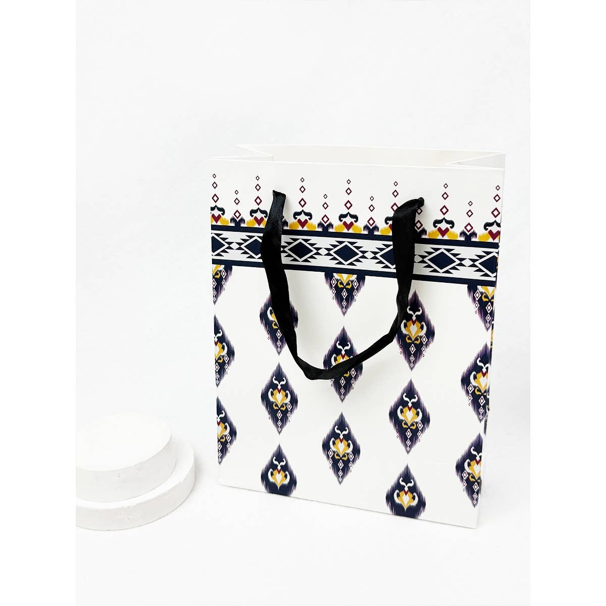 Tote bag with geometric pattern and black handles on a white background