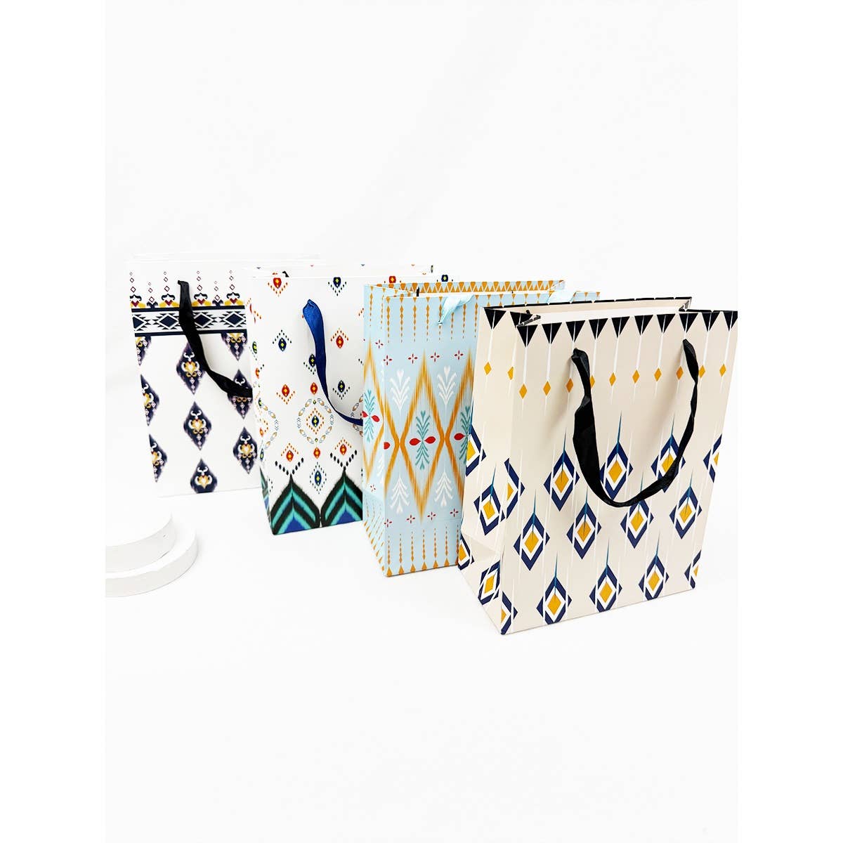 Assorted boho-style medium gift bags with geometric patterns and handles displayed together with size reference and individual designs