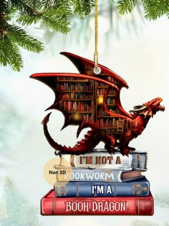 Acrylic ornament of a red dragon perched on books with book-filled wings hanging on a Christmas tree.