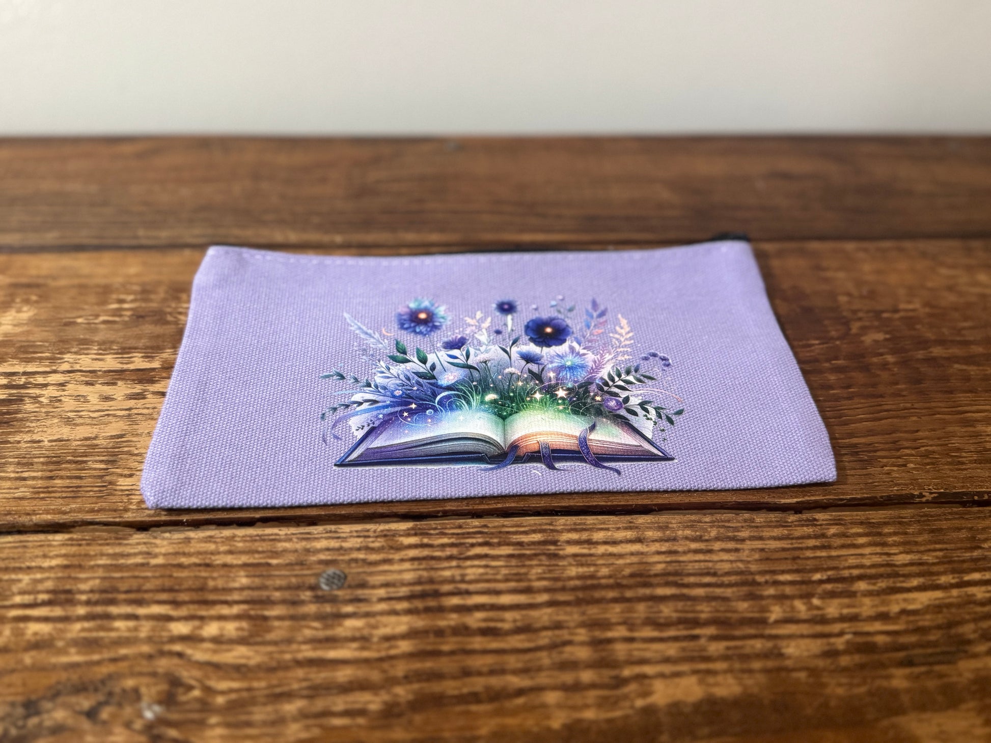 A beautifully designed accessories pouch featuring an image of a book with delicate flowers blooming from its pages. Perfect for book lovers, readers, and literary enthusiasts.