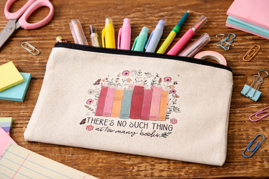 Canvas pencil pouch with books and flowers design and the phrase there’s no such thing as too many books, filled with pens and highlighters on a desk