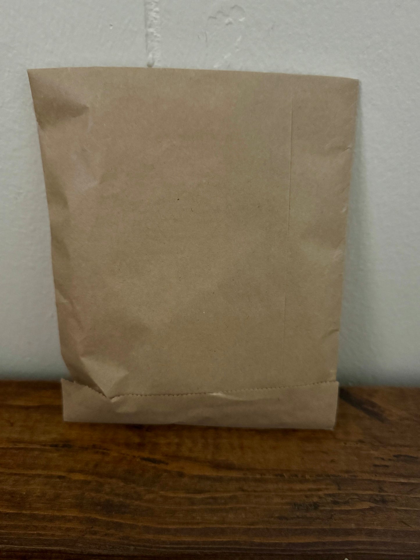 Brown bookish surprise bag containing assorted small bookish items and cozy mystery treats for readers.