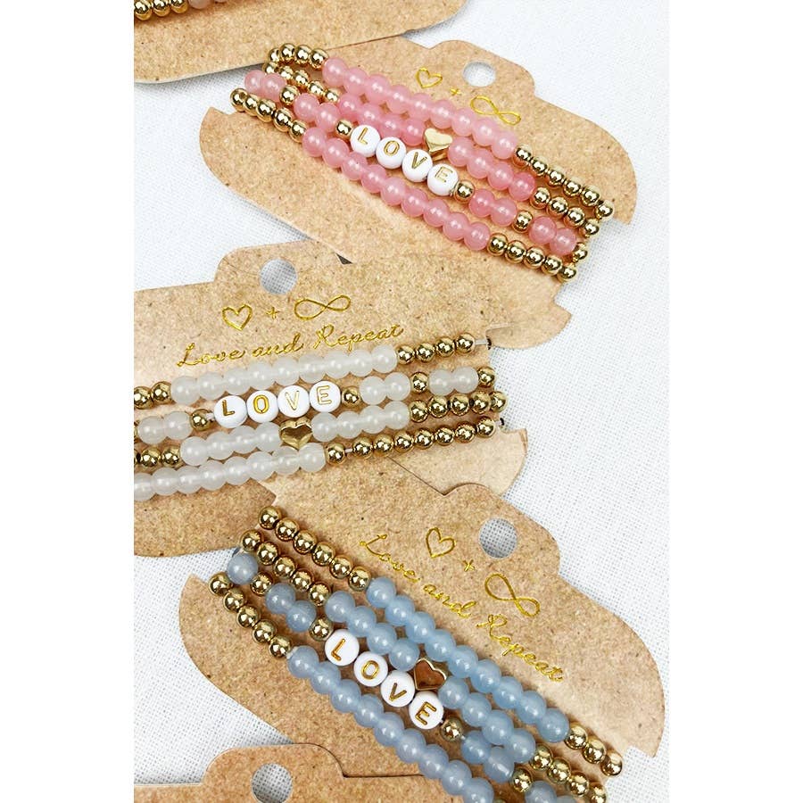 Handmade beaded bracelet with colorful beads and the word "LOVE" spelled out in white letter beads, perfect for casual wear or gifting.