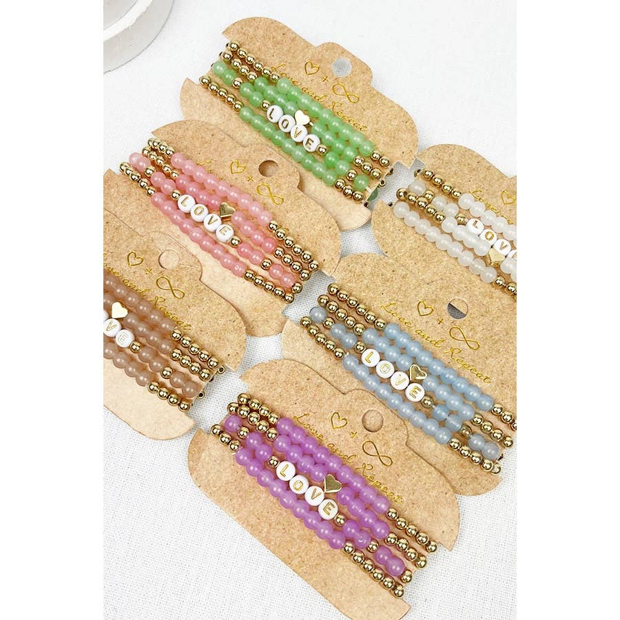 Handmade beaded bracelet with colorful beads and the word "LOVE" spelled out in white letter beads, perfect for casual wear or gifting.