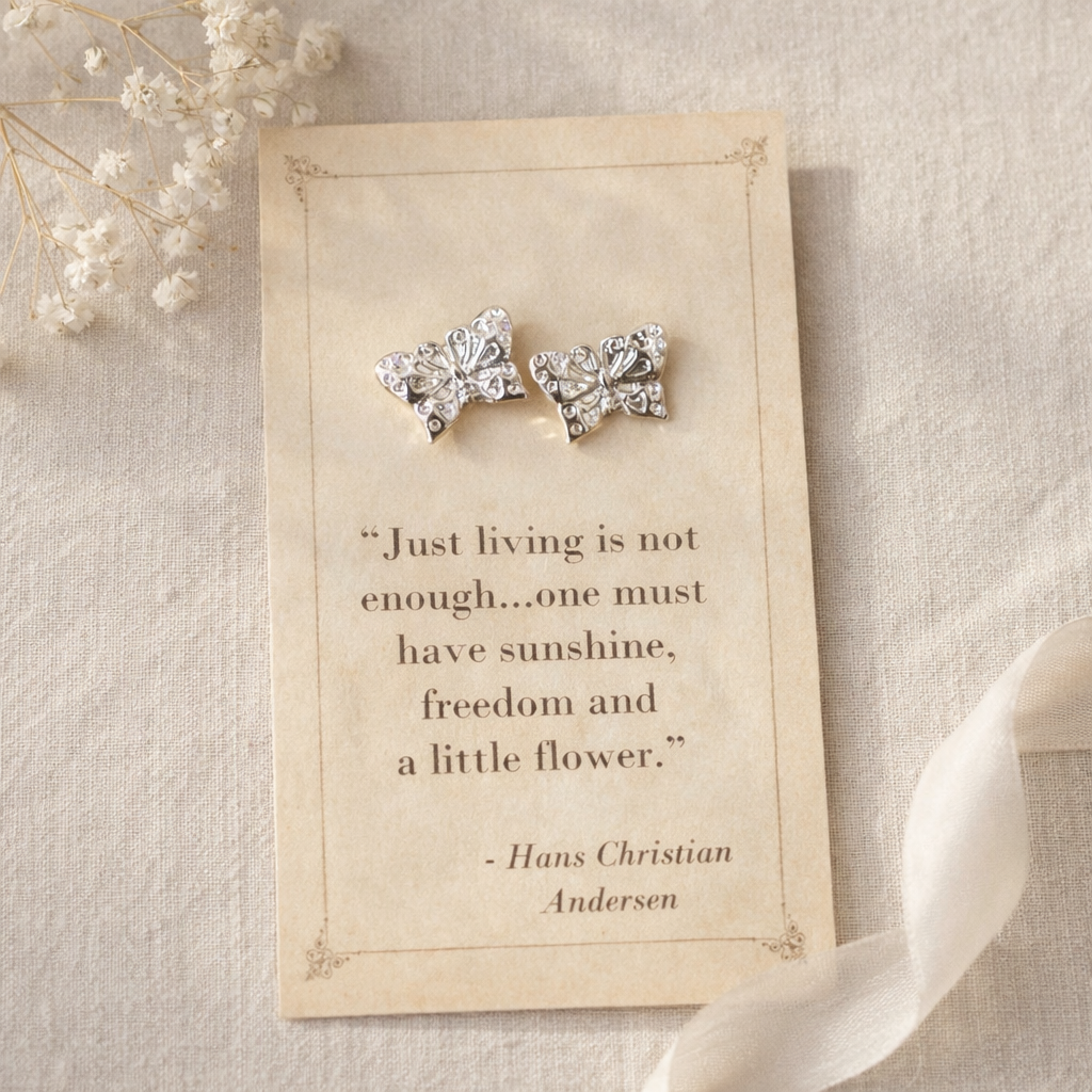 Silver butterfly stud earrings displayed on a vintage style quote card with soft neutral background and delicate floral accents