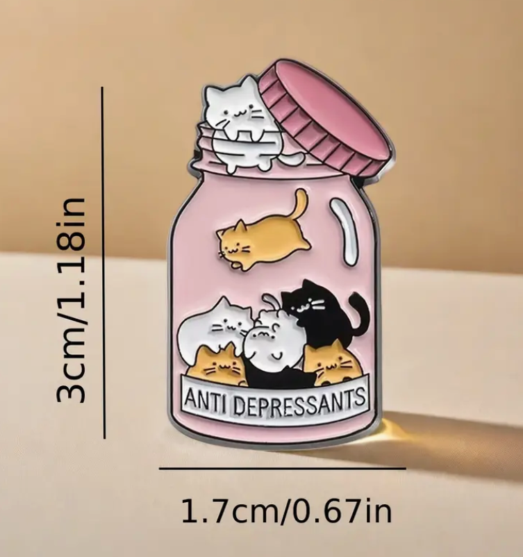 Cat Antidepressants enamel pin featuring a pink jar filled with cats and the words Antidepressants, cute and comforting accessory for cat lovers