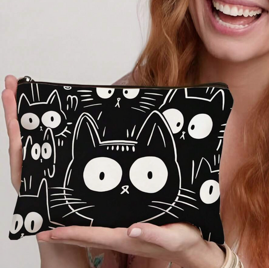 Person holding a black pouch with white cat illustrations