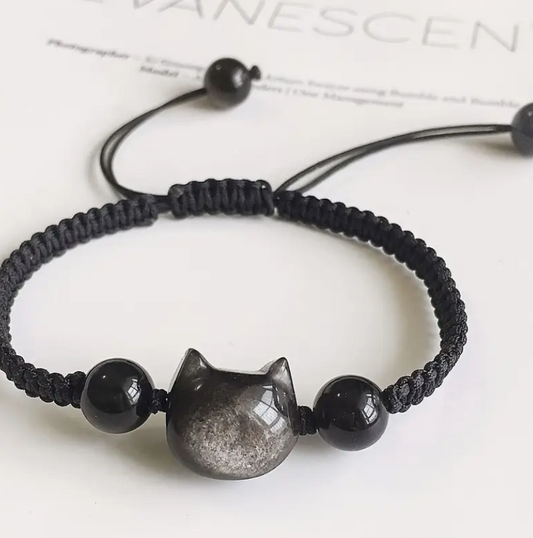 Black braided bracelet with a cat-shaped charm on a white background