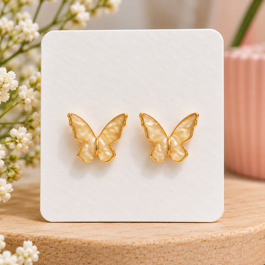 Champagne pearl butterfly stud earrings with creamy pearlescent wings and gold-tone trim