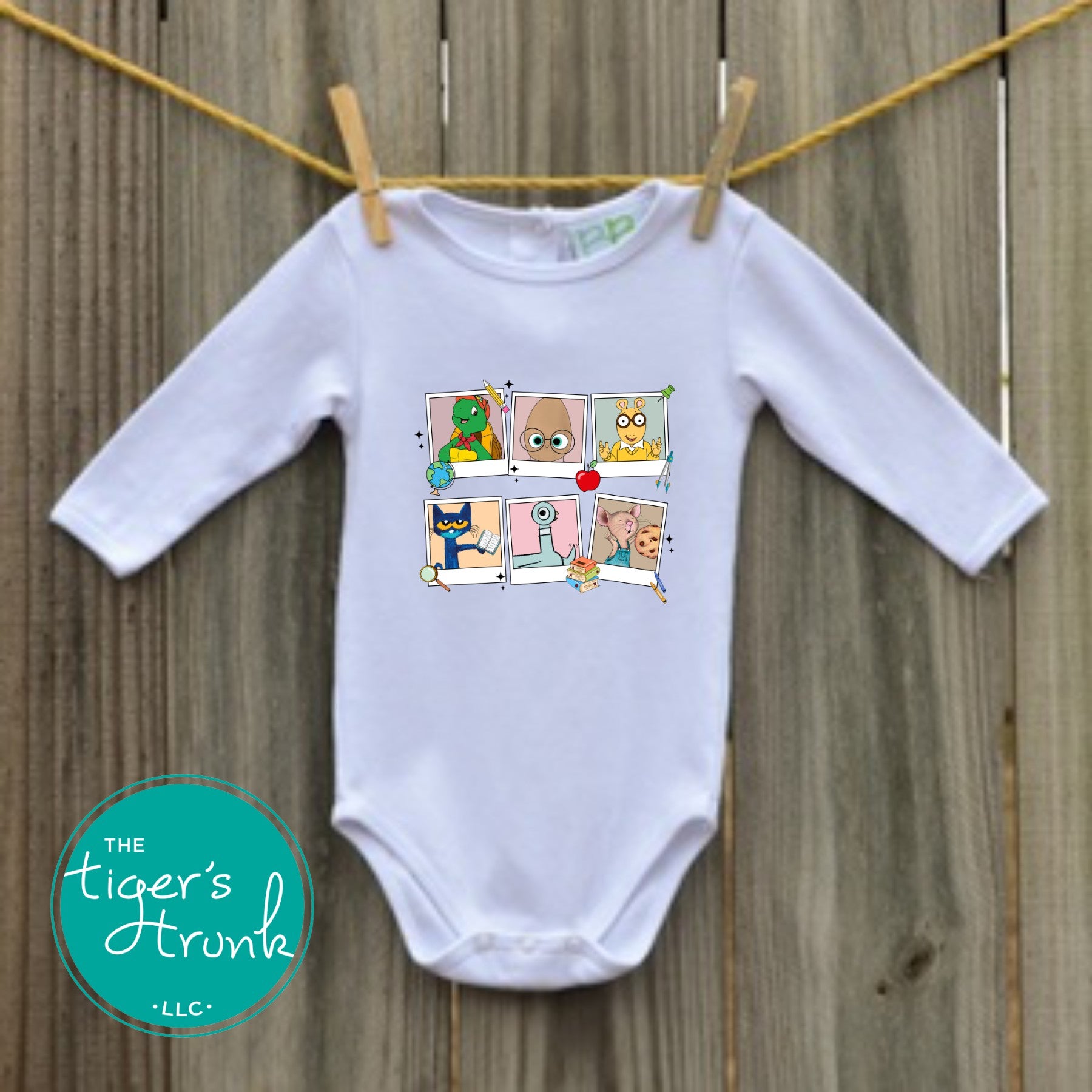 White long-sleeve baby bodysuit with colorful classroom character squares printed on the front, hanging on a clothesline.