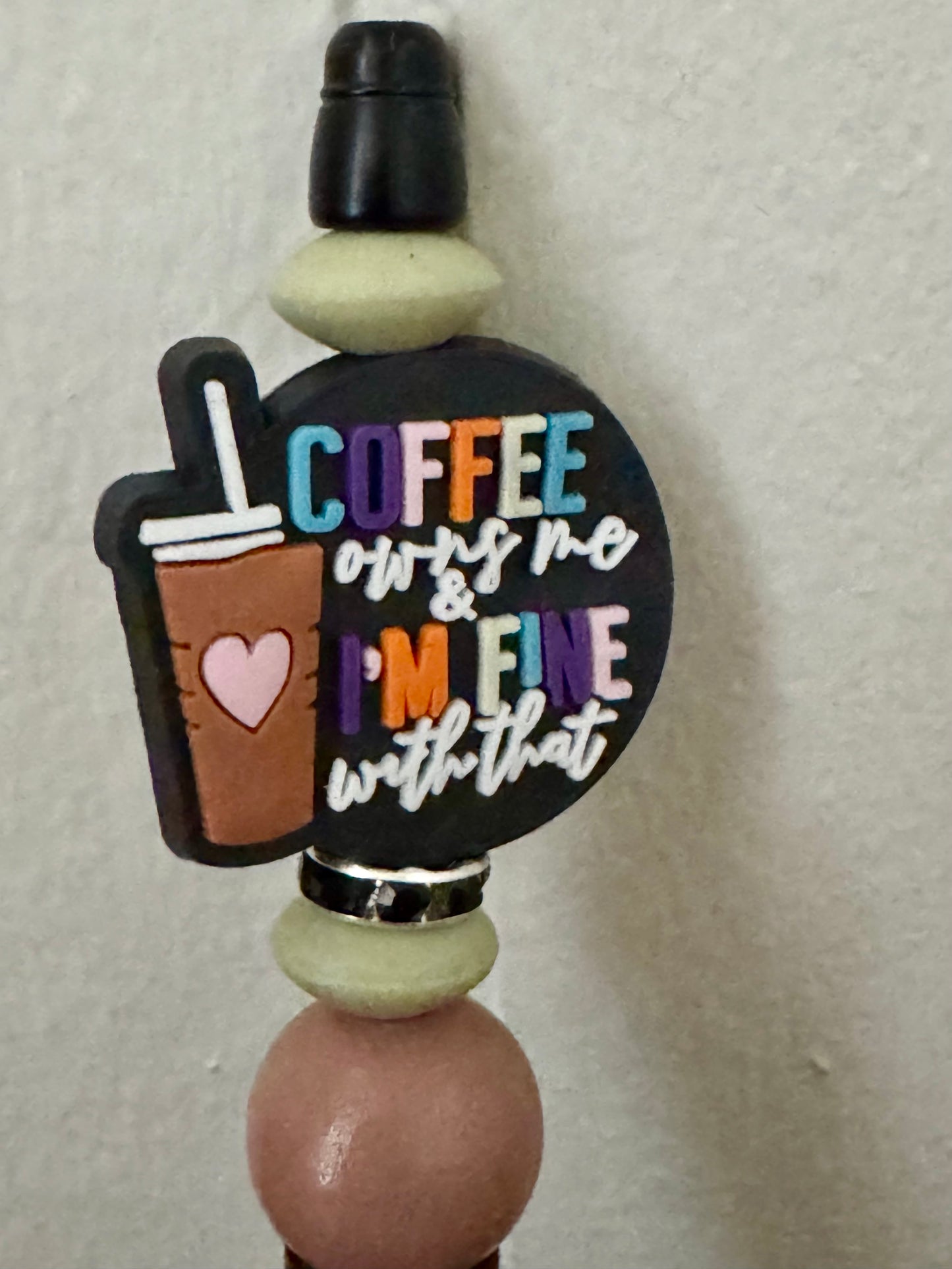 Decorative bottle stopper with coffee-themed text and design on a plain background