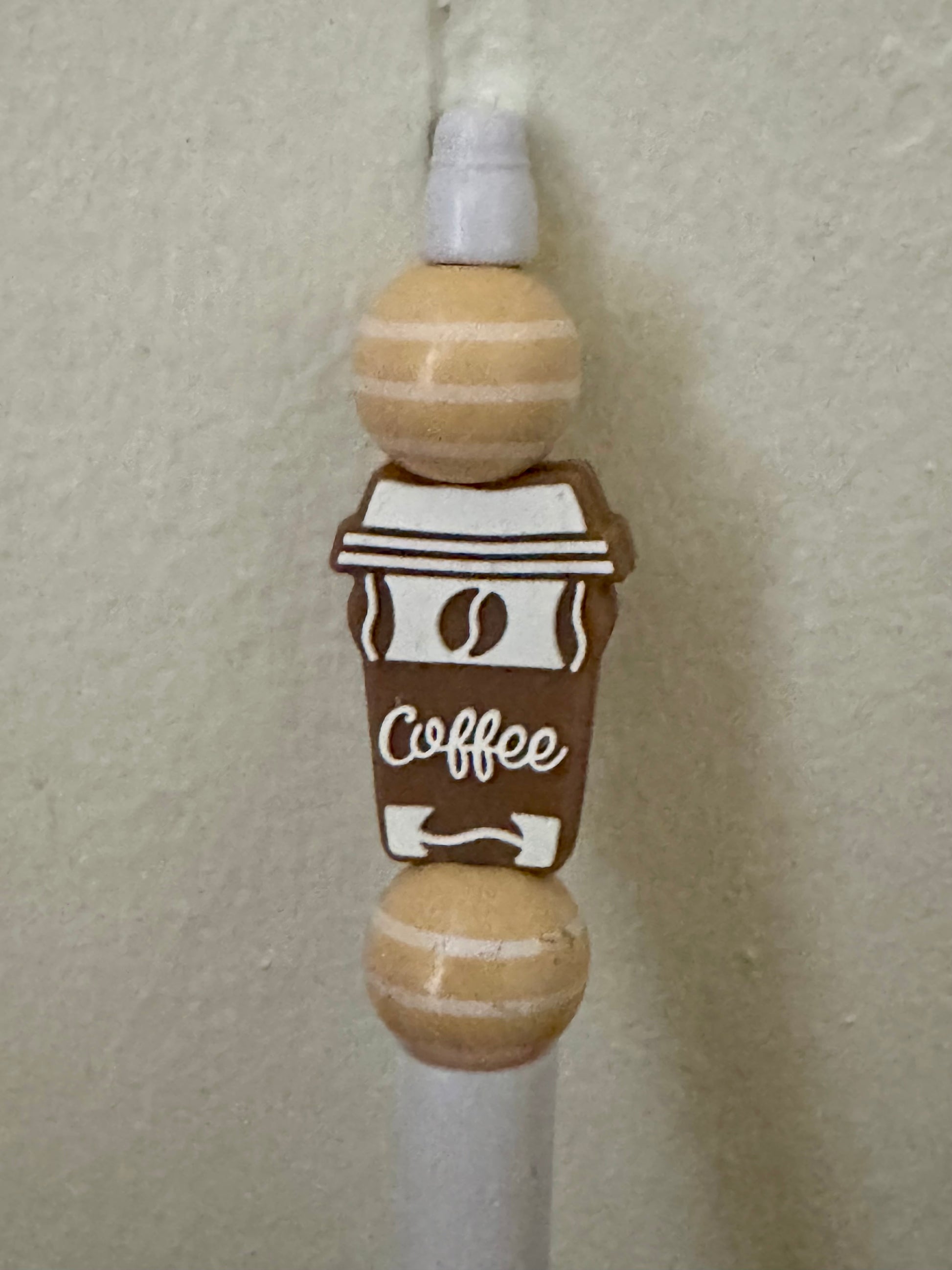 Decorative wooden item shaped like a coffee cup with 'Coffee' text on a plain background