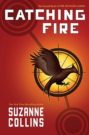 Cover of Catching Fire by Suzanne Collins, featuring a gold mockingjay pin against a fiery red background.