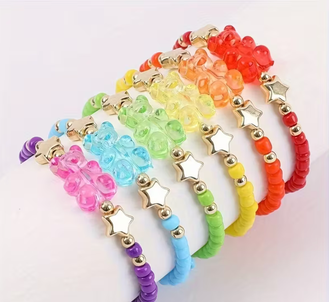 Assorted colorful stretch beaded bracelets with transparent gummy bear charms and gold star accents