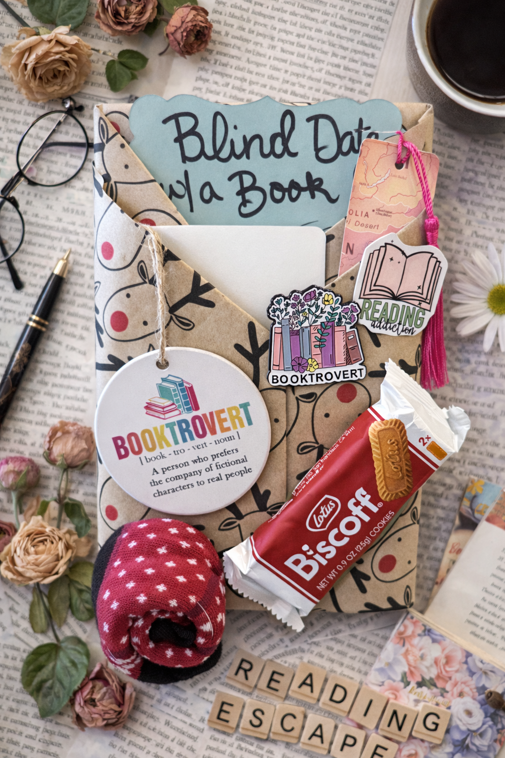 Book-themed stationery set with 'Blind Date with a Book' card, flowers, and a chocolate bar on a textured surface.