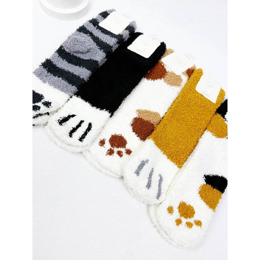 Flat lay of cozy fuzzy cat paw socks in assorted colors, styled with toe claw markings and paw pad designs on a white background.