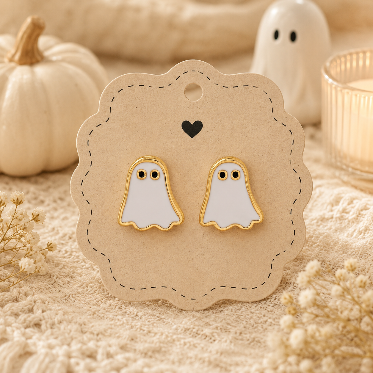 Pair of white ghost enamel stud earrings with gold-tone trim displayed on an earring card, perfect for Halloween and spooky season accessories.
