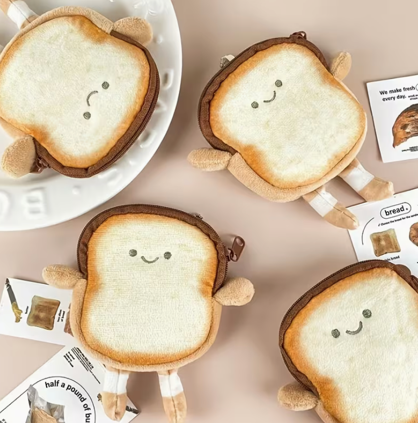 Cute plush toast-shaped coin purse with embroidered smiling face, tiny arms and legs, and zipper closure, approximately 4.5 by 4 inches