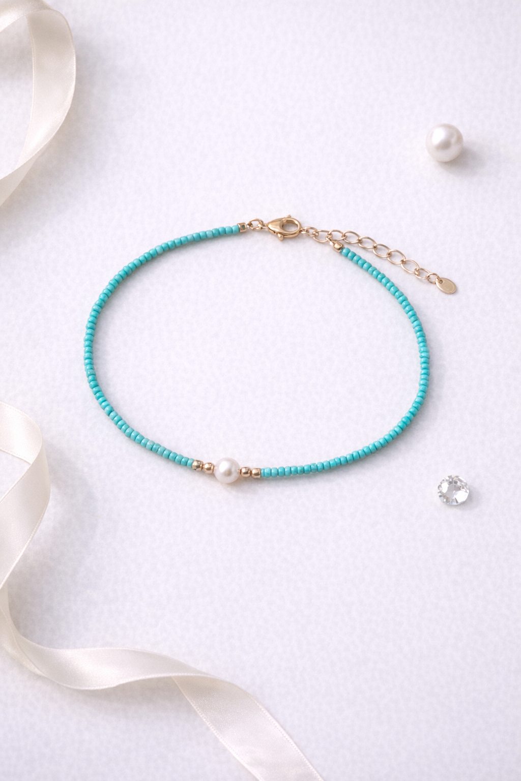 Delicate green beaded necklace with pearl accent and adjustable clasp displayed on white background