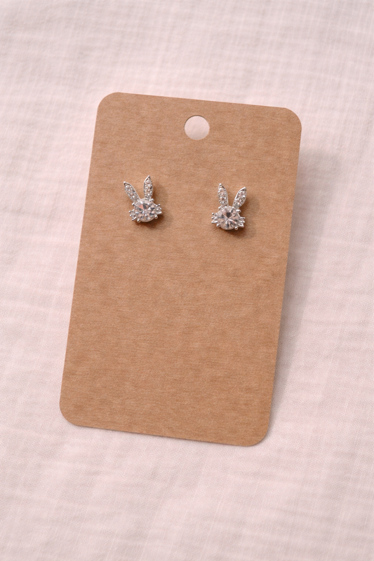 Silver diamond bunny stud earrings displayed on kraft jewelry card