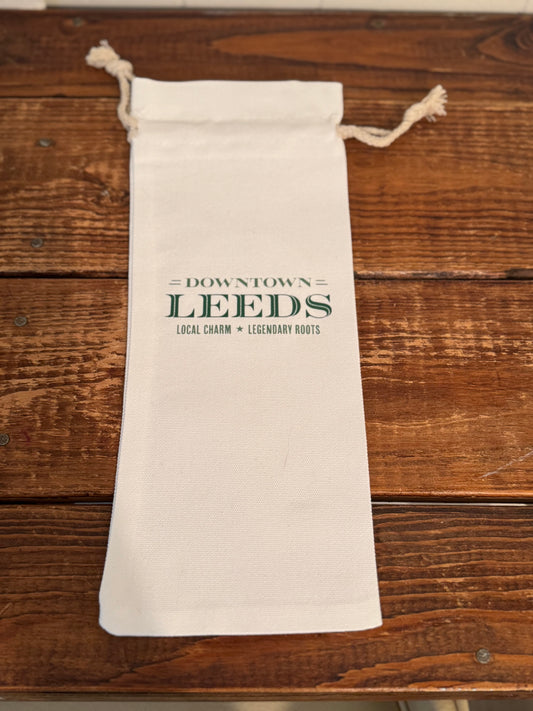 White drawstring bag with 'Downtown Leeds' text on a wooden surface