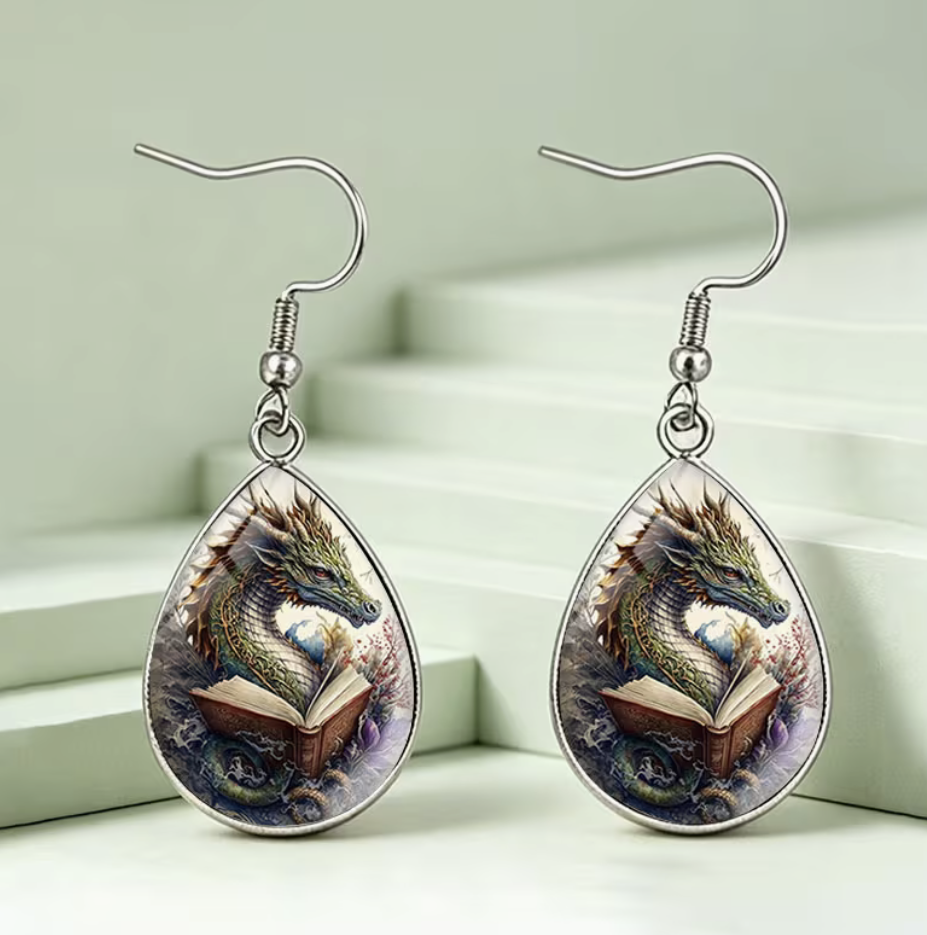 Pair of teardrop dangle earrings featuring a fantasy dragon reading an open book