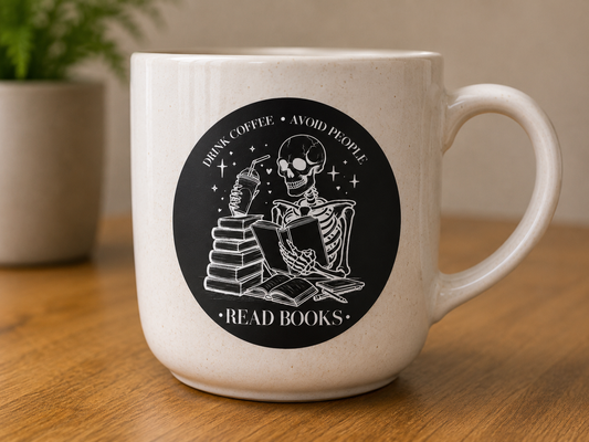 Black and white vinyl sticker featuring a reading skeleton with coffee and the phrase Drink Coffee Avoid People Read Books.