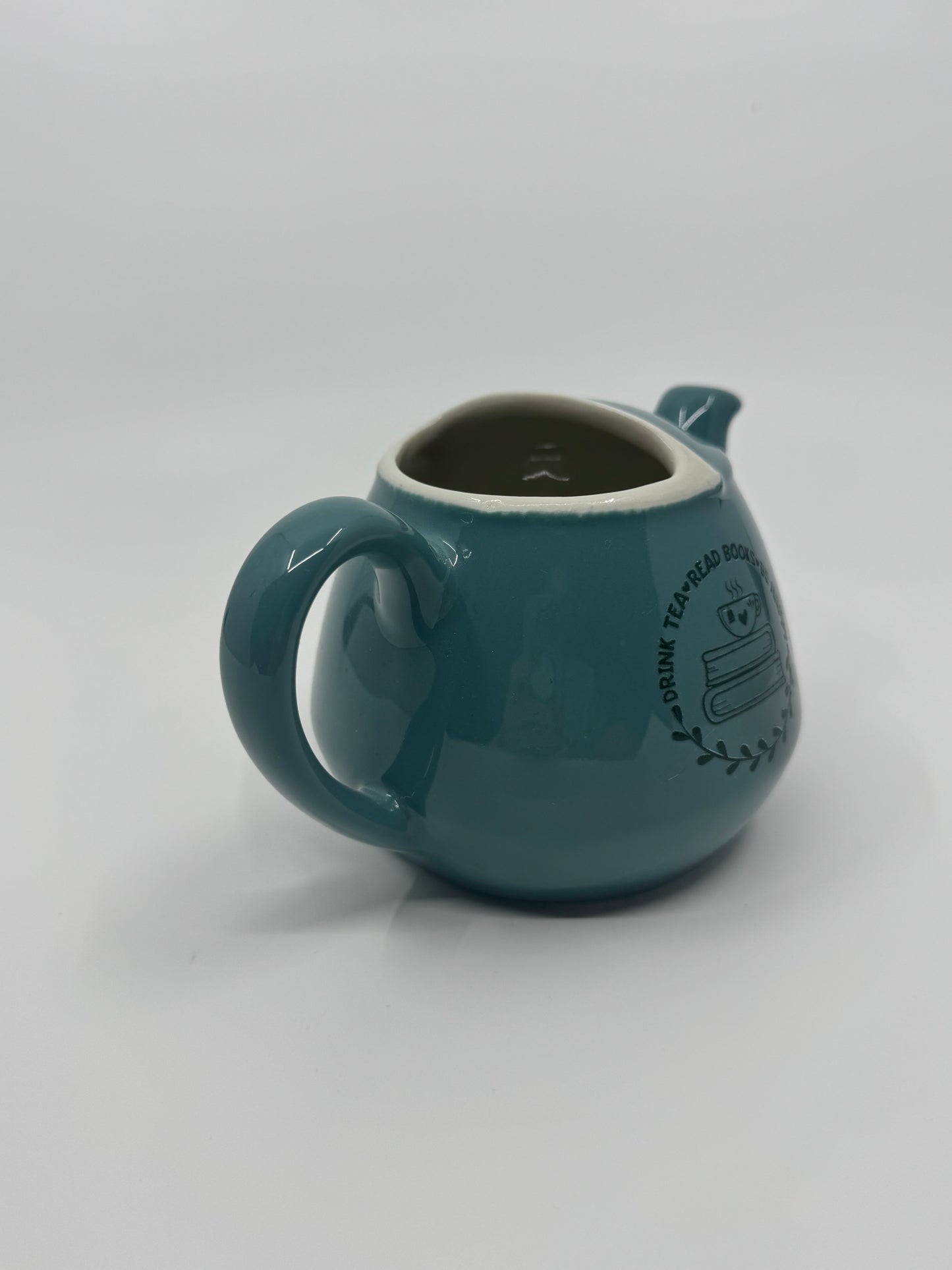 Teal ceramic mug with a handle on a white background