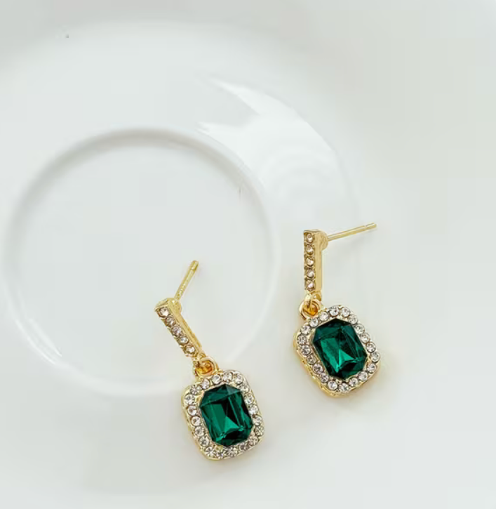 Emerald green rectangular faux gemstone drop earrings with gold-tone settings and sparkling clear rhinestone accents