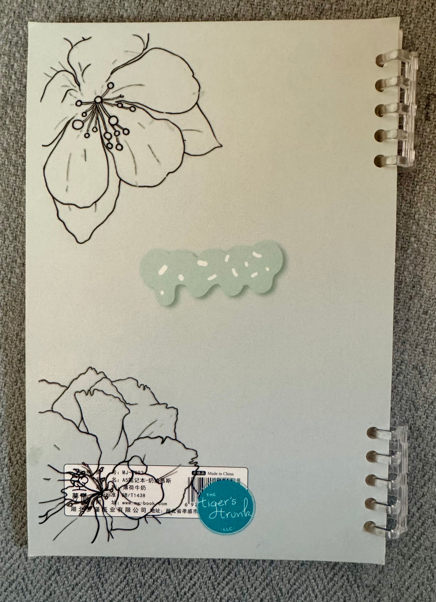 Back cover of Endless Lists of Shit to Do lined journal with minimalist floral line art and clear disc binding on a neutral textured background.