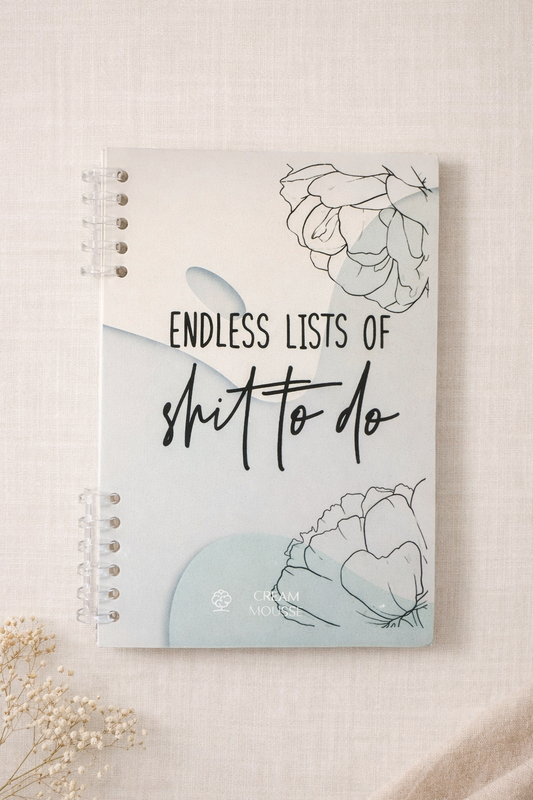 Front cover of Endless Lists of Shit to Do lined journal by Cream Mousse with floral design and clear disc binding on neutral fabric background.