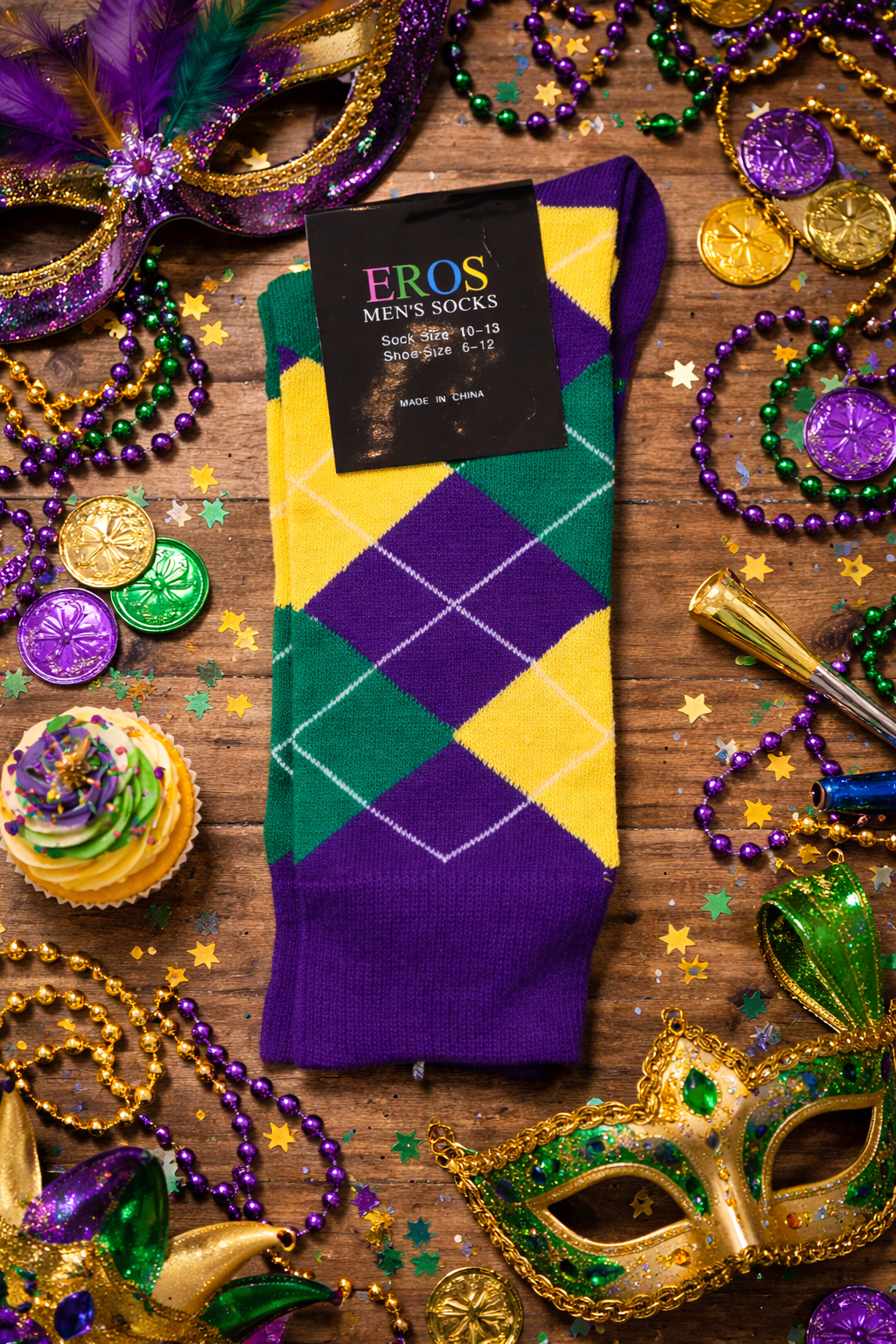 EROS men’s argyle crew socks in purple, green, and gold diamond pattern with retail hang tag showing sock size 10–13 and men’s shoe size 6–12, styled in a Mardi Gras flatlay with masks, beads, coins, confetti, and festive decorations on a wooden background.