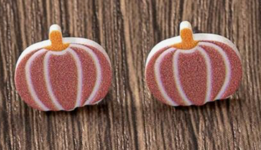 Pair of pumpkin-shaped earrings on a wooden surface