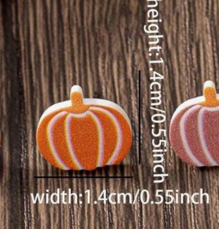 Pumpkin-shaped earrings with measurements on a wooden background