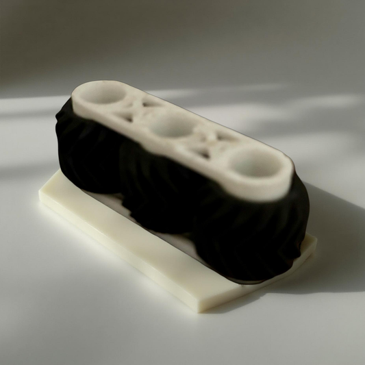 Small 2.5 inch spinning fidget toy with three textured wheels on a black frame, resting on a light surface