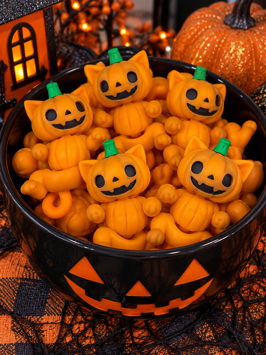 Cute orange 2-inch 3D printed flexi pumpkin cat fidget toys with jack-o'-lantern faces displayed together in a festive Halloween bowl.