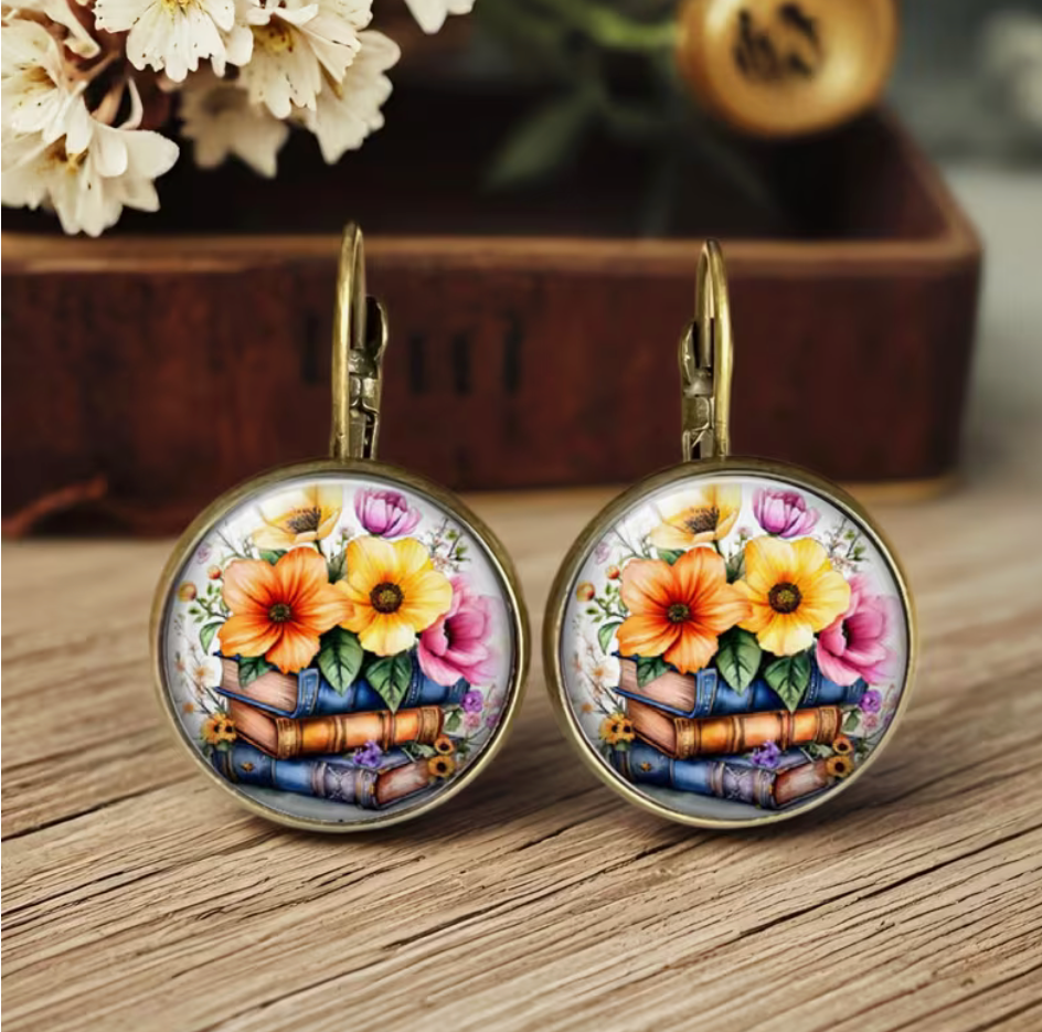 Round bookish earrings featuring colorful flowers arranged on a stack of vintage-style books