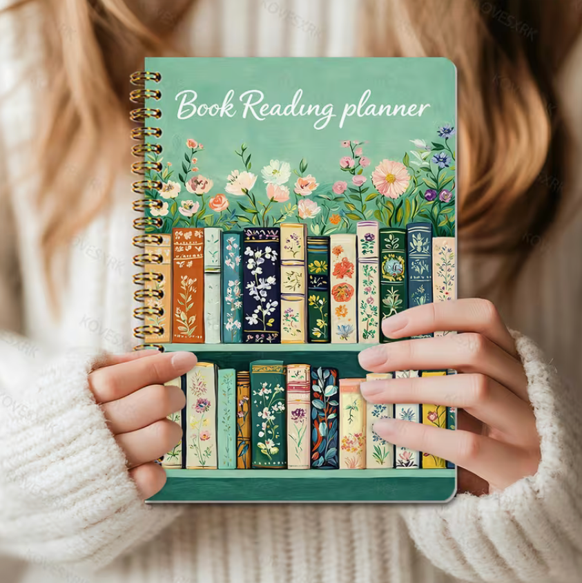 Book Reading planner with floral and book design held by a person wearing a white sweater.