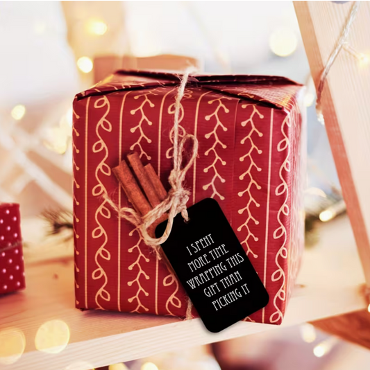 Funny Christmas gift tag attached to a wrapped red holiday present