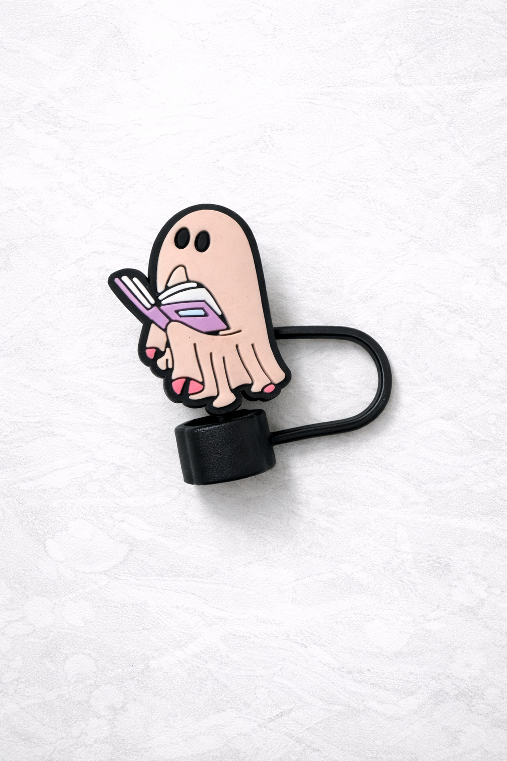 Silicone straw topper featuring a cute ghost holding an open book, attached to a black flexible loop for reusable tumbler straw.
