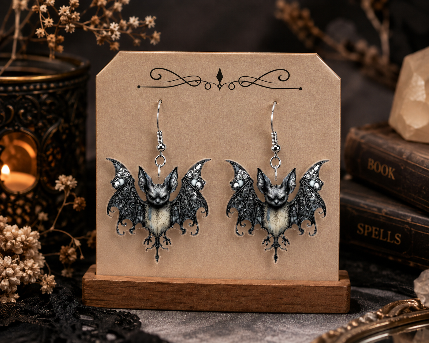 Gothic bat acrylic dangle earring with ornate black wings and silver-tone fishhook ear wire.