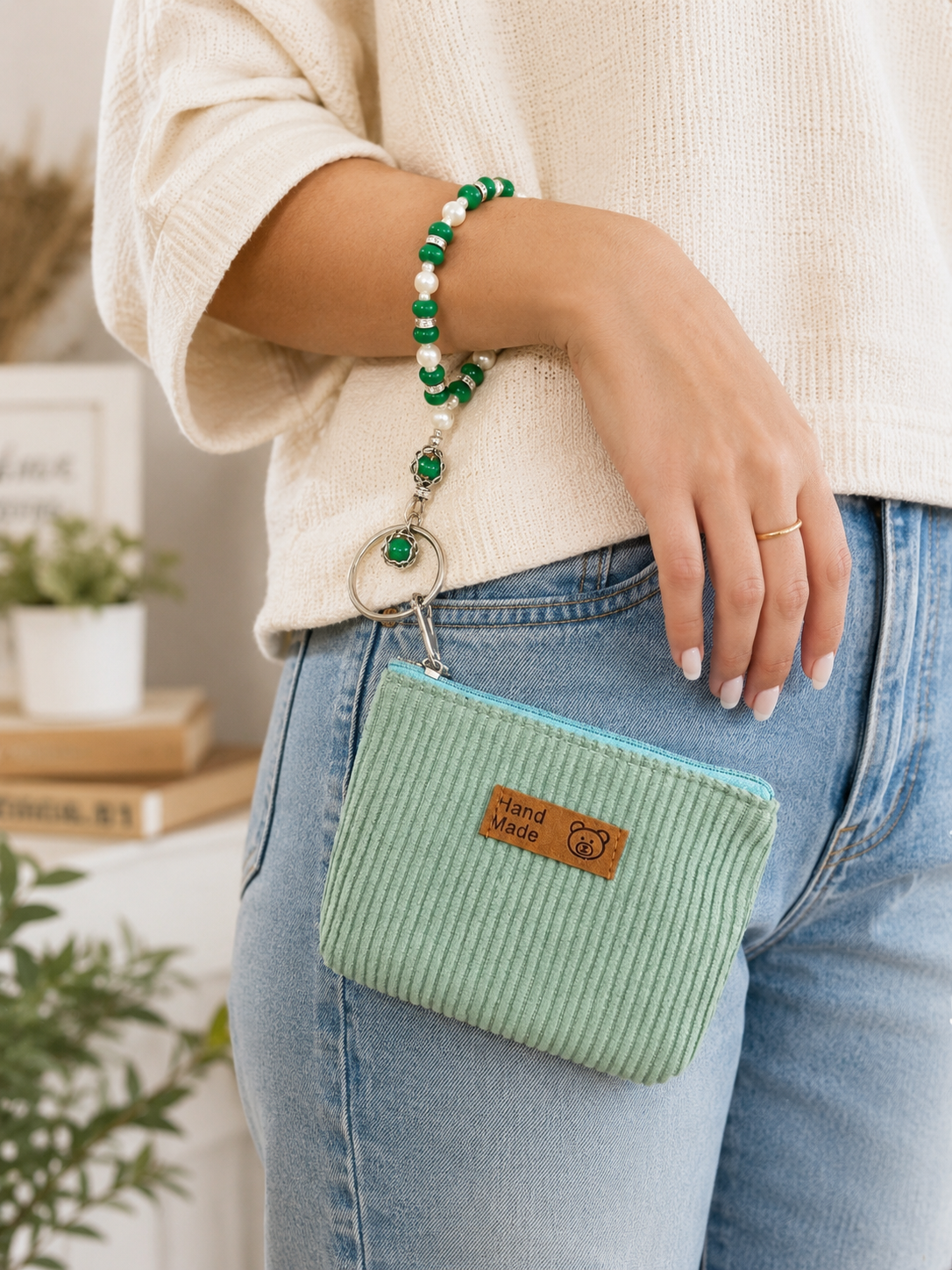 Green and white beaded wristlet keychain with mint pouch worn around wrist